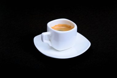 Klasik espresso kahve ve pralin siyah arka plan üzerine beyaz fincan.