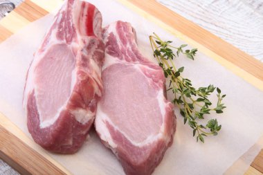 Çiğ domuz eti, baharat ve biberiye kesme tahtası üzerinde. Hazır yemek pişirmek için.