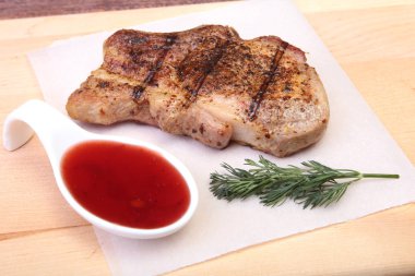 ızgara domuz eti ile kızılcık sosu ahşap tahta üzerinde plaka üzerinde