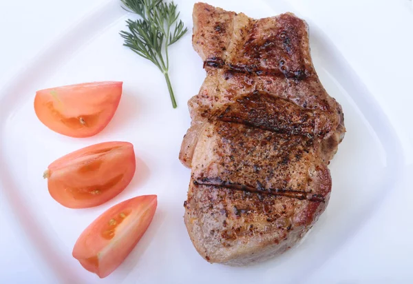 Gegrilde pork chop met plantaardige op plaat op houten bord — Stockfoto