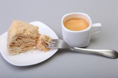 Ev yapımı Napoleon puf pasta plaka ve geleneksel espresso kahve beyaz arka plan üzerinde izole. yakın çekim.