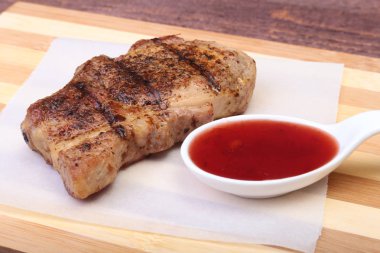 ızgara domuz eti ile kızılcık sosu ahşap tahta üzerinde plaka üzerinde