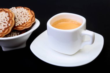 Klasik espresso ile ev yapımı kek siyah arka plan üzerine beyaz Kupası'nda. Seçici odak.