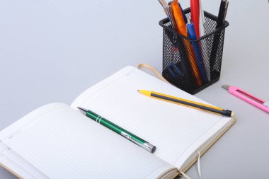 Açık boş sayfa defter ve kalem beyaz masada.