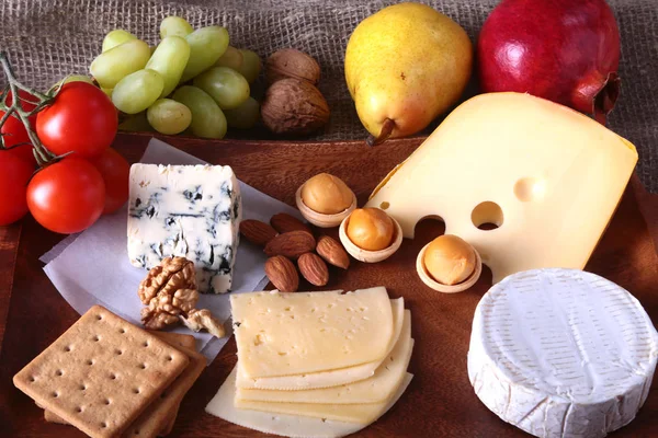 Meyve, üzüm ve fındık bir ahşap servis tepsi ile peynir çeşitleri.
