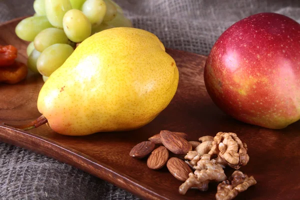 Свежие органические фрукты на деревянном подносе. Ассорти яблоко, груша, виноград, сухофрукты и орехи . — стоковое фото