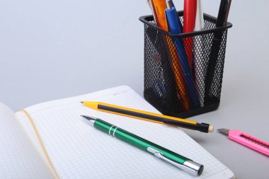 Açık boş sayfa defter ve kalem beyaz masada.