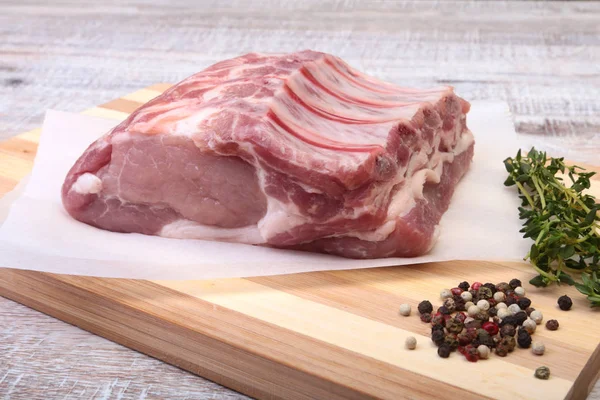 Çiğ domuz eti, baharat ve biberiye kesme tahtası üzerinde. Hazır yemek pişirmek için.