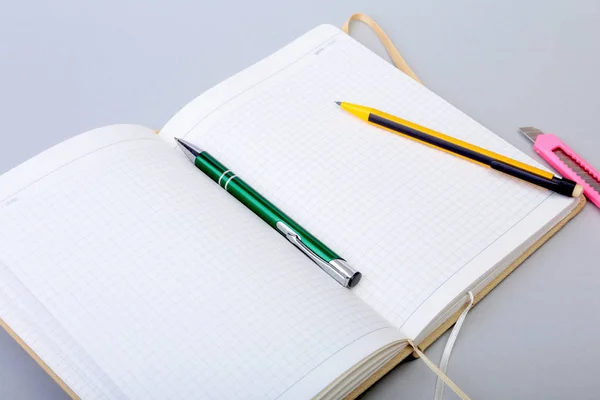 Nyitott üres oldal notebook és a toll, a fehér asztal. — Stock Fotó