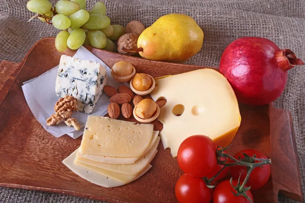 Meyve, üzüm ve fındık bir ahşap servis tepsi ile peynir çeşitleri.