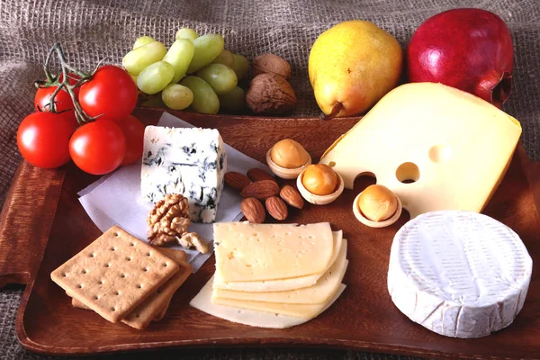 Meyve, üzüm ve fındık bir ahşap servis tepsi ile peynir çeşitleri.