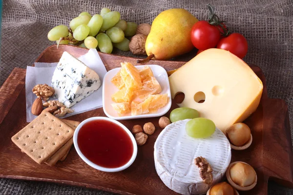 Meyve, üzüm ve fındık bir ahşap servis tepsi ile peynir çeşitleri.