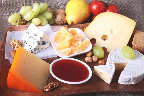Meyve, üzüm ve fındık bir ahşap servis tepsi ile peynir çeşitleri.