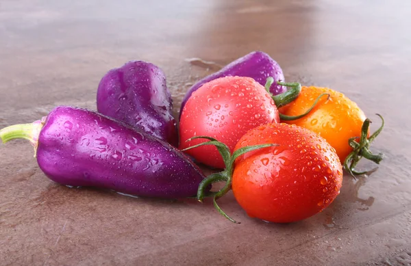 Vegetal sortido com pimentão cor exótica roxo e tomates isolados no fundo de pedra . — Fotografia de Stock