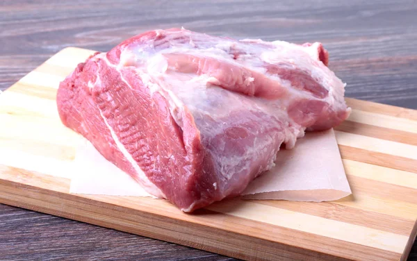 Filetes de cerdo crudos sobre tabla de madera con hierbas, ajo y especias listas para cocinar. Enfoque selectivo . —  Fotos de Stock