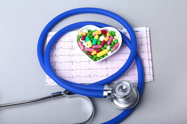 Стетоскоп, RX рецепт и красочные таблетки ассортимента и капсулы на тарелке
.