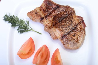 ahşap tahta üzerinde plaka üzerinde sebzeli ızgara domuz pirzolası