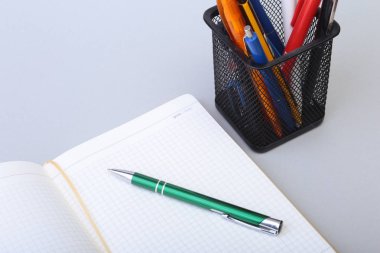 Açık boş sayfa defter ve kalem beyaz masada.