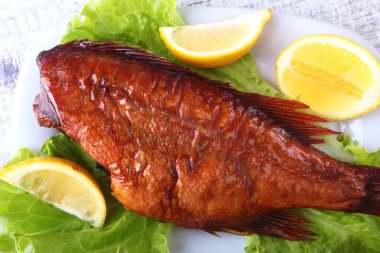 Füme balık ve beyaz arka plan üzerinde izole tahta kesme tahta üzerinde yeşil marul yaprakları limon.