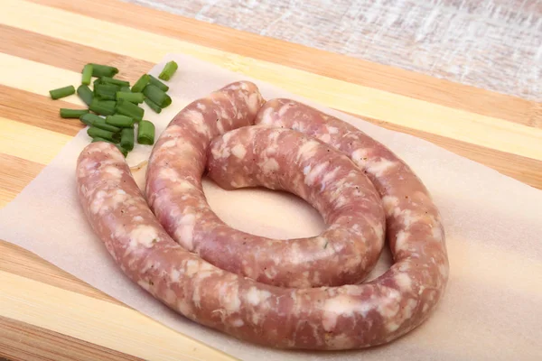 Ahşap arka plan üzerinde baharatlar ile ev yapımı çiğ sosis.