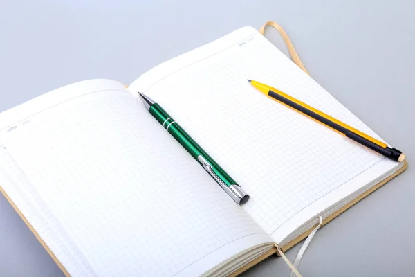 Nyitott üres oldal notebook és a toll, a fehér asztal. — Stock Fotó