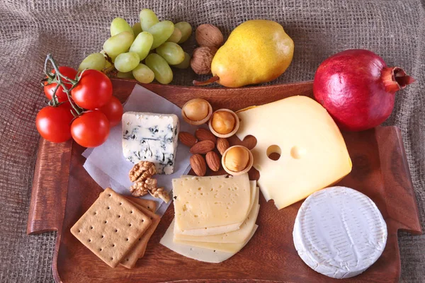 Meyve, üzüm ve fındık bir ahşap servis tepsi ile peynir çeşitleri.