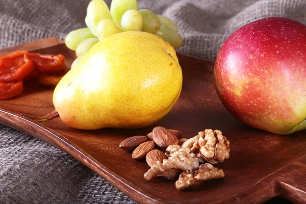 Свежие органические фрукты на деревянном подносе. Ассорти яблоко, груша, виноград, сухофрукты и орехи . — стоковое фото