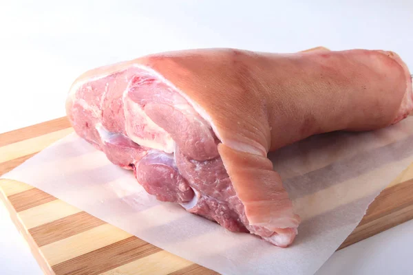 Nudillo de cerdo crudo en una tabla de cortar. Enfoque selectivo. Listo para cocinar . —  Fotos de Stock