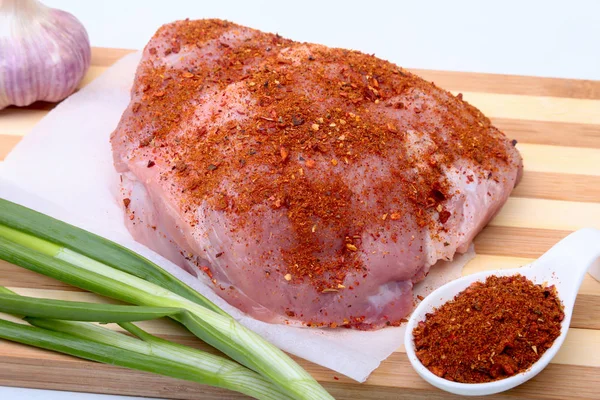 Steaks de porc avec de la graisse. La viande est sur une planche de bois avec des épices comme le poivre et l'oignon vert de printemps. Prêt pour la cuisine. Concentration sélective . — Photo