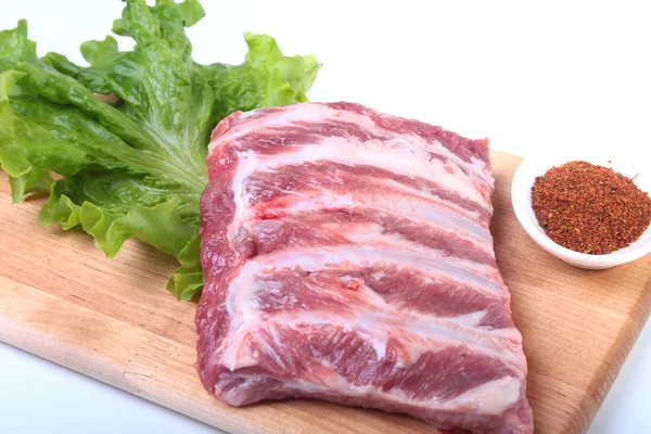 Otlar ve baharatlar ahşap tahta üzerinde çiğ Domuz kaburga. Hazır yemek pişirmek için.