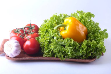 Taze çeşitli sebze çan biber, domates, sarımsak yaprak marul ile. Beyaz arka plan üzerinde izole. Seçici odak.