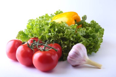 Taze çeşitli sebze çan biber, domates, sarımsak yaprak marul ile. Beyaz arka plan üzerinde izole. Seçici odak.