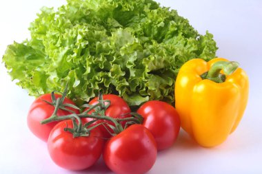 Taze çeşitli sebze çan biber, domates, sarımsak yaprak marul ile. Beyaz arka plan üzerinde izole. Seçici odak.