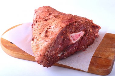 Çiğ domuz knuckle ve baharat bir kesme tahtası üzerinde. Seçici odak. Hazır yemek pişirmek için.