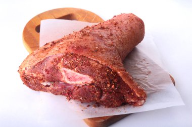 Çiğ domuz knuckle ve baharat bir kesme tahtası üzerinde. Seçici odak. Hazır yemek pişirmek için.