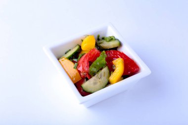 domates, salatalık, biber ve marul yaprağı beyaz kase taze sebze salatası.