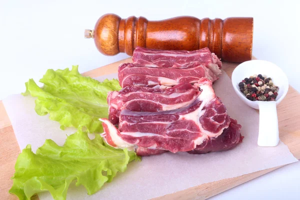 Bords de boeuf cru, feuille de laitue, moulin à poivre et épices sur un bureau en bois isolé sur fond blanc d'en haut et espace de copie. prêt pour la cuisson . — Photo