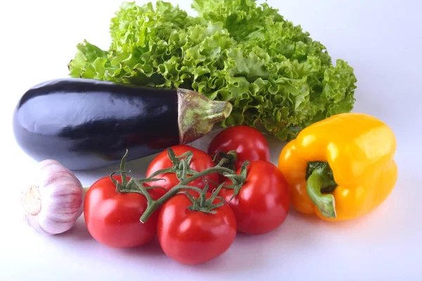 Fresh assorted vegetables, eggplant, bell pepper, tomato, garlic with leaf lettuce. Isolated on white background. Selective focus. — Stock Photo, Image