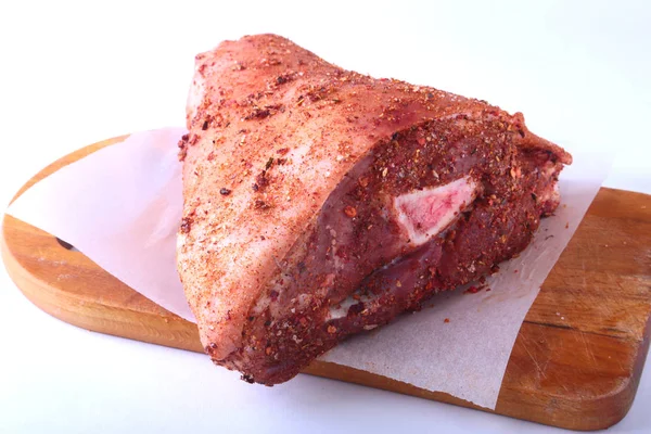 Çiğ domuz knuckle ve baharat bir kesme tahtası üzerinde. Seçici odak. Hazır yemek pişirmek için.