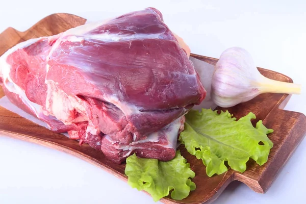 Steak de boeuf cru et feuilles de laitue sur une planche à découper. Concentration sélective. Prêt pour la cuisson . — Photo