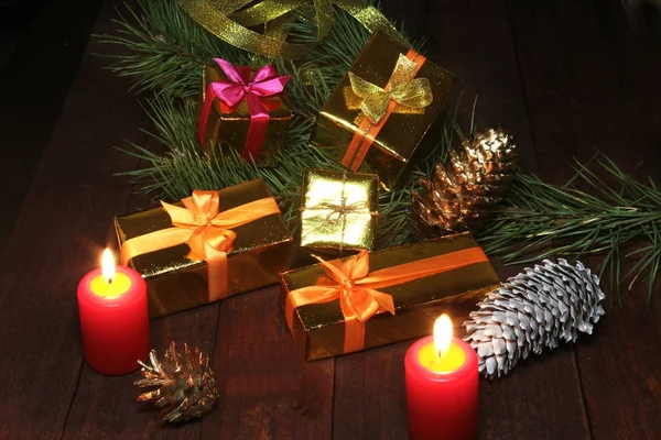 Christmas gift colored boxes, cones, Christmas tree and candles on a wooden table. Composition of celebrities. Selective focus. — Stock Photo, Image
