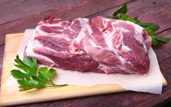 Carne cruda de chuleta de cerdo con hojas de perejil sobre un fondo de piedra. Listo para cocinar . — Foto de Stock