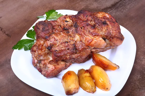 Juicy pork neck chops are grilled with potatoes on a white plate. — Stock Photo, Image