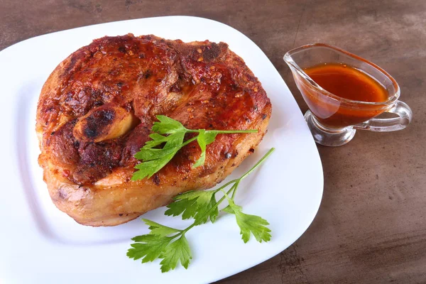 Жареная свиная отбивная с соусом на деревянном столе . — стоковое фото
