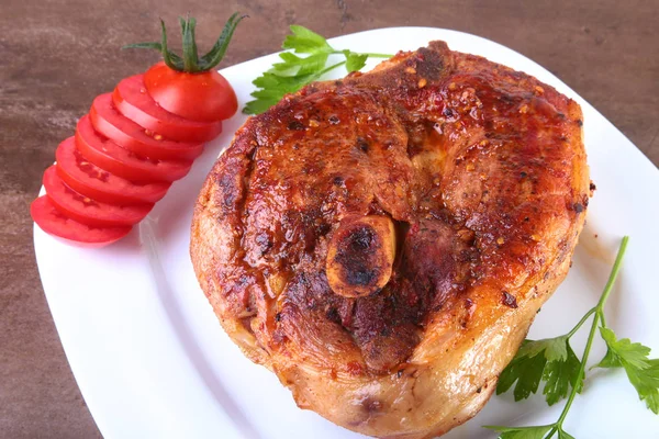 Chuleta de cerdo a la parrilla con tomate en rodajas y salsa sobre mesa de madera . —  Fotos de Stock