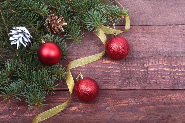 Рождественское украшение с красивыми красочными шарами, елкой и лентами на деревянном фоне . — стоковое фото