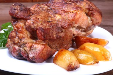 Beyaz bir tabak patates ile sulu domuz boyun eti ızgara.
