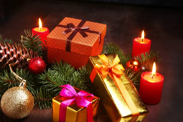 christmas decoration with gift boxes, red candles, christmas tree and colorful balls. Selective focus.