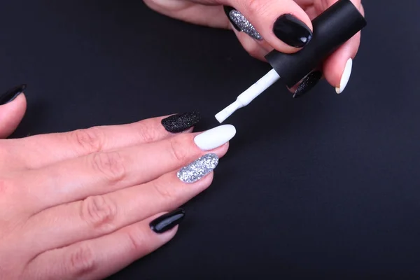 Manicura de uñas blancas y negras. Estilo de vacaciones brillante Manicura con destellos. Botella de esmalte de uñas. Manos de belleza. Clavos con estilo, esmalte de uñas — Foto de Stock