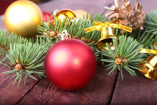 Weihnachtsdekoration mit schönen bunten Kugeln, Tannenbaum und Tannenzapfen auf Holzgrund. — Stockfoto